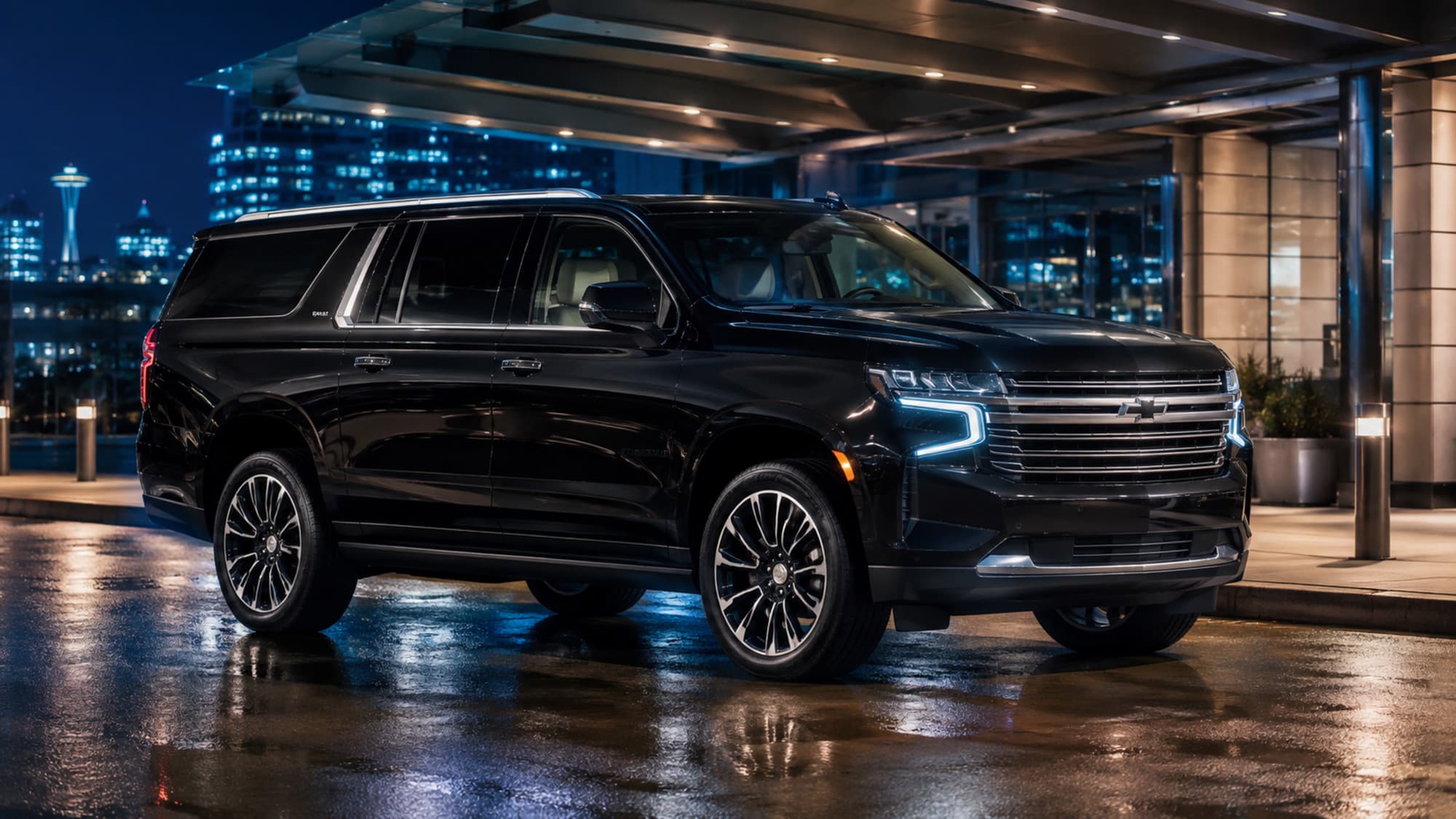 A black 2022 Chevrolet Suburban under a hotel portico at night